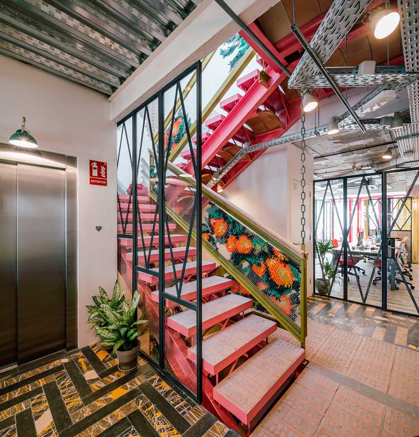 Escalera central y ascensor del coworking Clementina