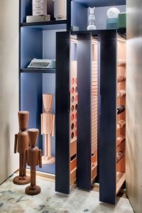Detalle del interior del armario en Casa Decor 2021, con estanterías lacadas y figuras artesanales de madera