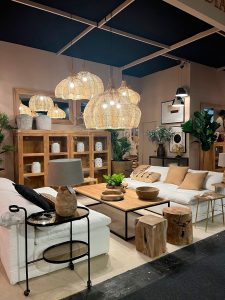 Salón con sofás blancos, muebles de madera y pantallas de fibra