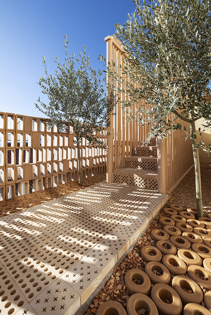 Escalera revestida con gres extrusionado y olivos integrados en la instalación arquitectónica de Nuet y Mayice en Casa Decor 2026.